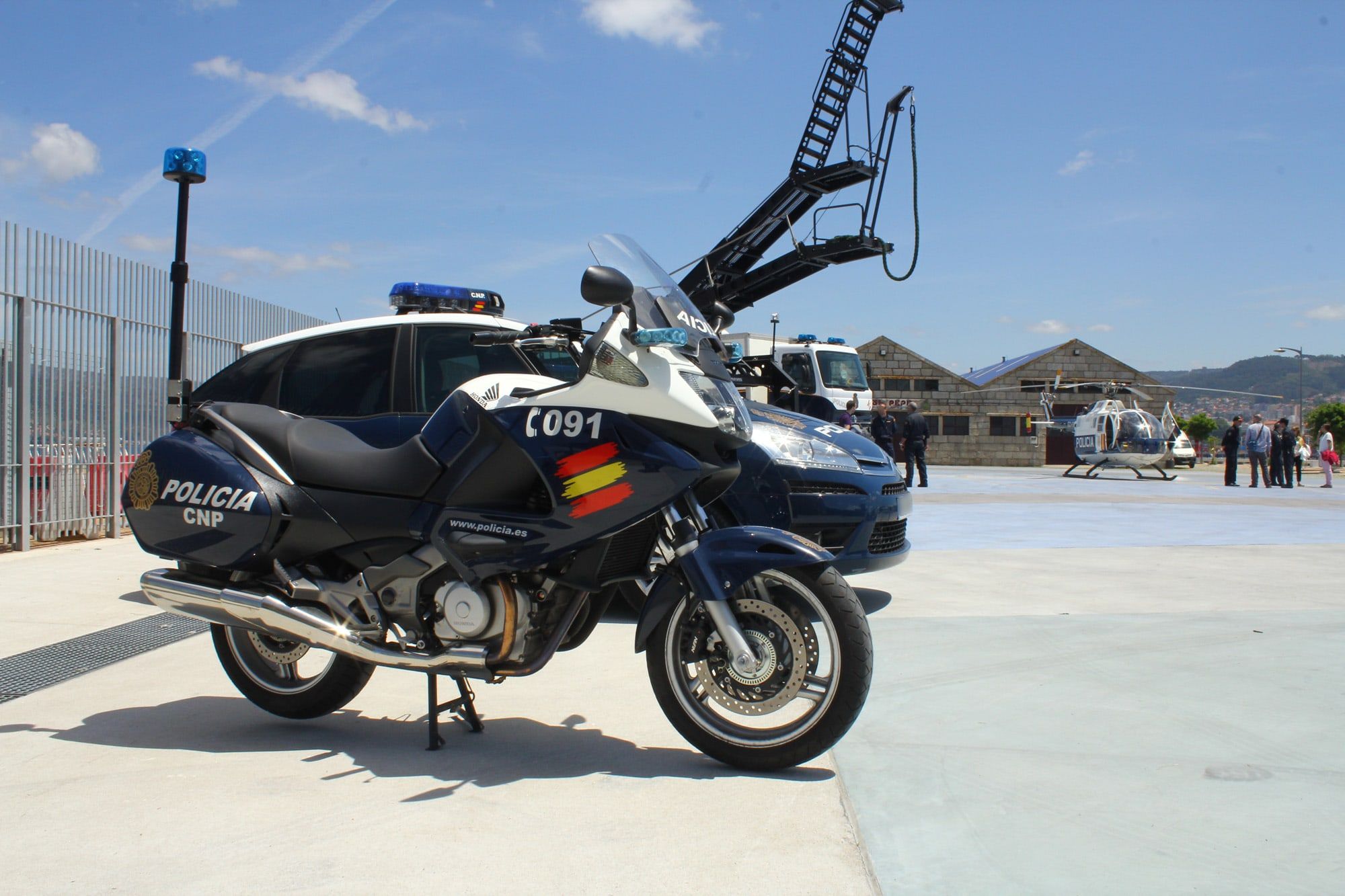 Moto y coche patrulla de la Policía Nacional aparcados al sol